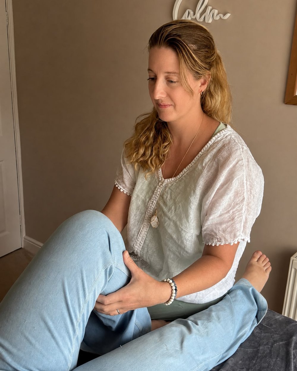 Theresa performing a Bowen Technique treatment on a client's knee