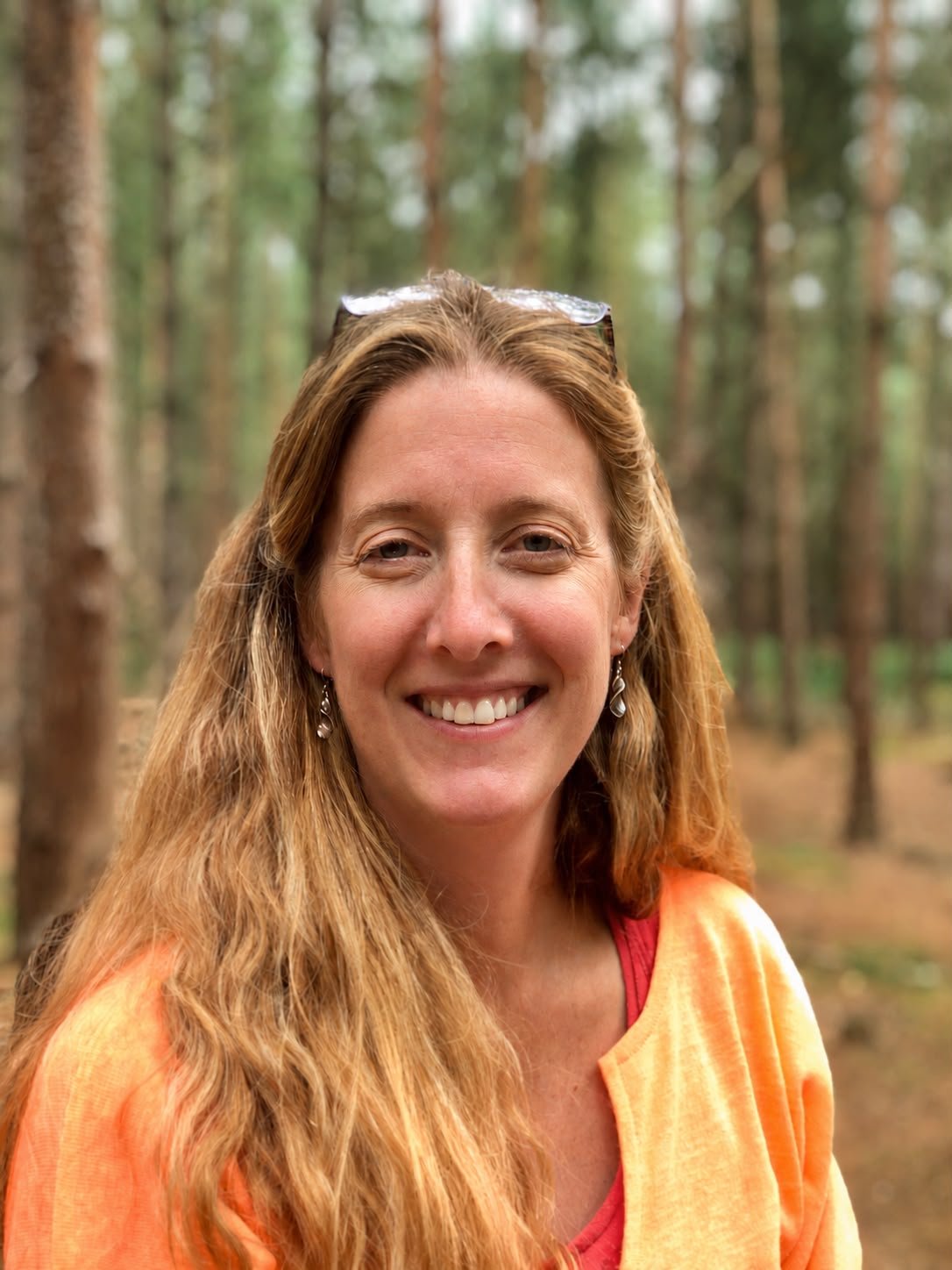Theresa, founder of Sacred Flow Healing, in a pine woodland